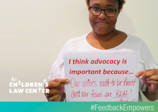 Advocate holding sign to promote the #FeedbackEmpowers campaign