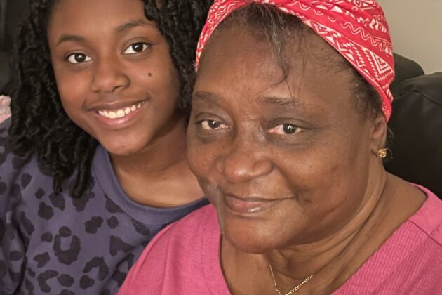 Smiling teenager sitting with her grandmother.