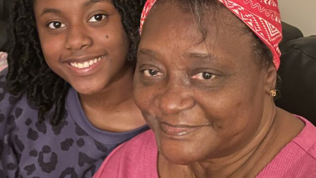 Smiling teenager sitting with her grandmother.