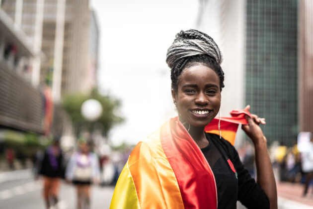 Woman carrying LGTBQ+ flag.