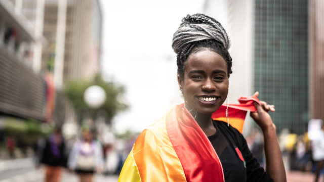 Woman carrying LGTBQ+ flag