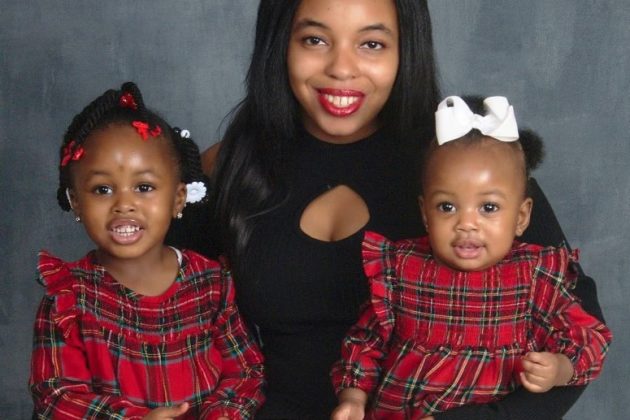Photo of mom and two daughters smiling at camera.