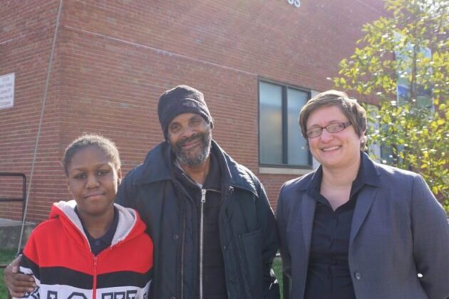 Photo of Destiny, her grandfather Tyrone, and their lawyer Rebecca outside Destiny's new school.