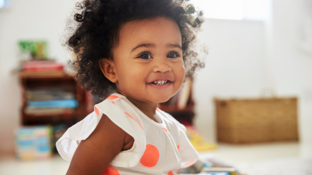 Photo of young child looking past camera and smiling